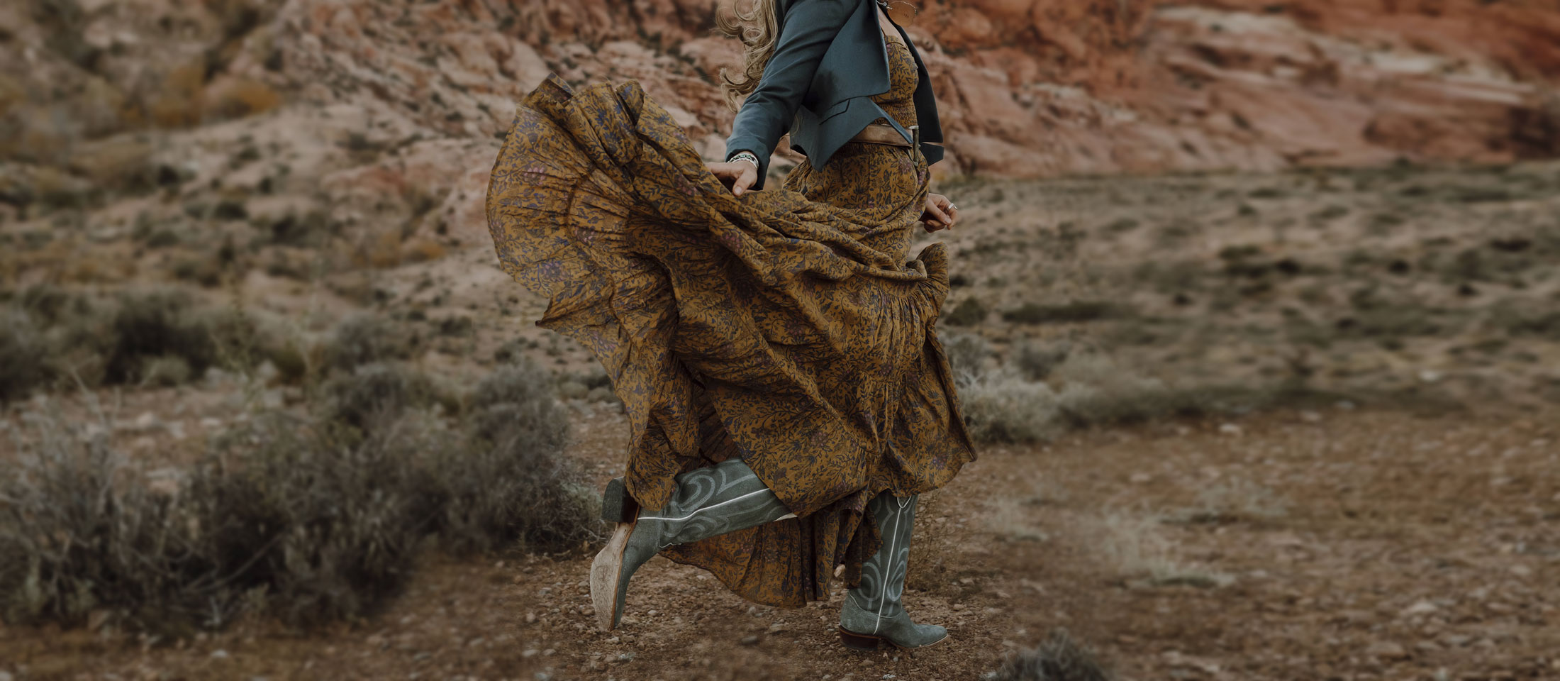 A woman wearing Justin Vintage boots dancing in the desert 